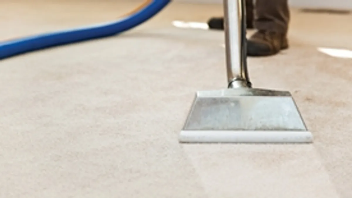 Carpet cleaning wand head gliding over a light carpet during hot-water extraction, Ogden, UT.